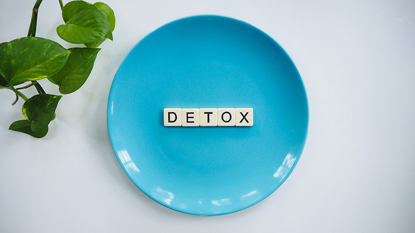 cleanses - detox writing in scrabble tiles laid out on a blue plate